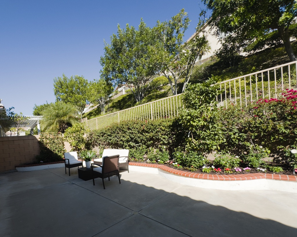 The back yard looking to the north east with patio furniture in front of lush landscaping.